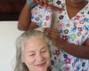 a caregiver combing a senior woman's hair